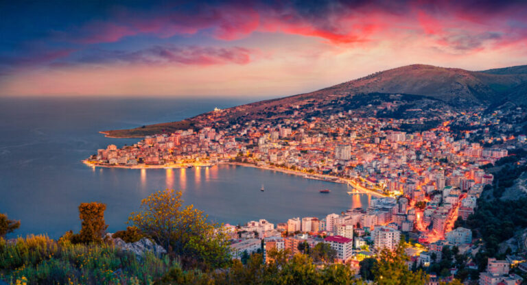 Aerial morning cityscape of Saranda port. Majestic sunrise on Ionian sea. Fantastic outdoor scene of Albania, view from Lekursi Castle. Traveling concept background.